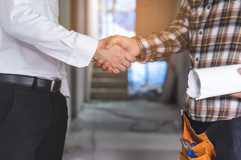 Contractor shaking hands with a client on site